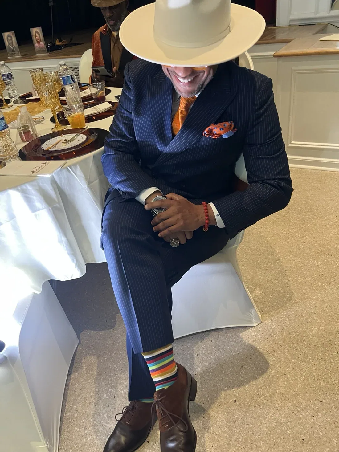 Dr. Johnson seated in a navy pinstripe suit and cream hat