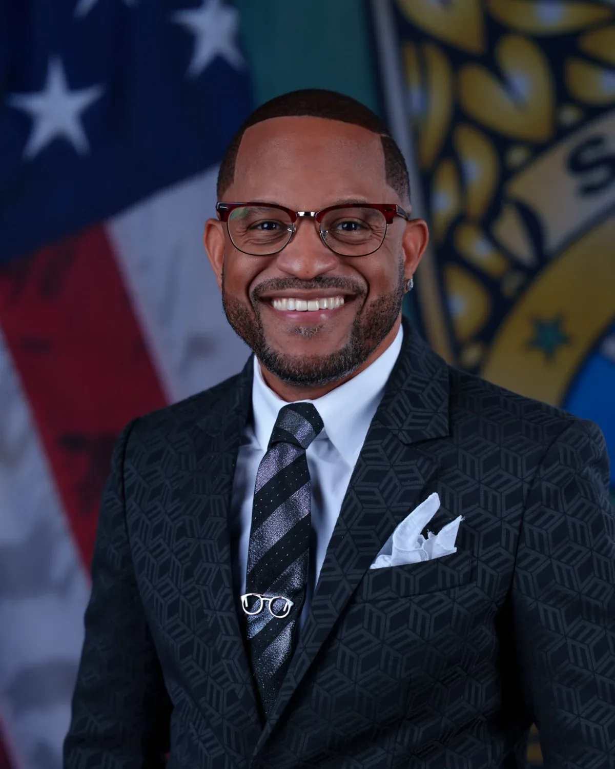 Dr. Jeffery Johnson smiling in a dark patterned suit